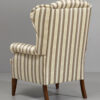 Wysoki fotel Uszak 1.8 w tkaninie Alexandria w złoto beżowe pasy. Widok z tyłu.